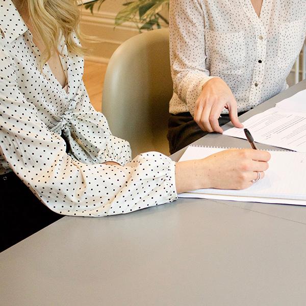 Two female work colleages working and looking through some paperwork